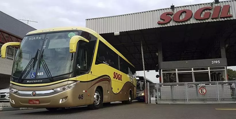 A foto mostra um Ônibus da SOGIL parado em frente a garagem da empresa